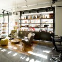 George Northwood's Hair Salon, Fitzrovia / View of ground floor showing micro-cement flooring and bespoke steel & hardwood shelving