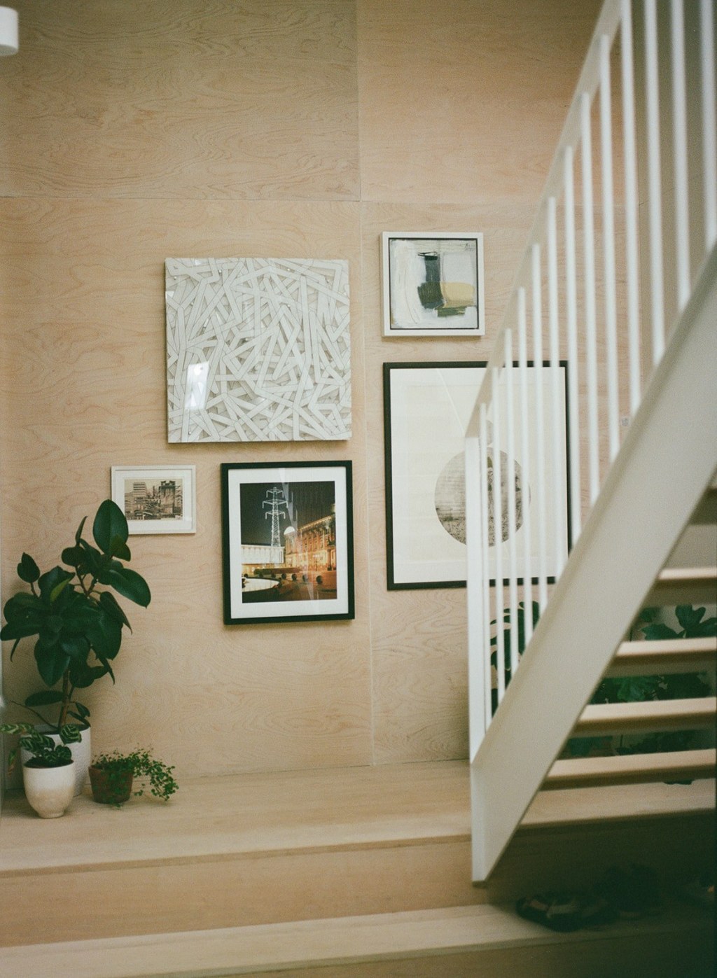 The Coach House London / A warm timber stairwell provides a wall for art and a respite from the minimalist concrete floor